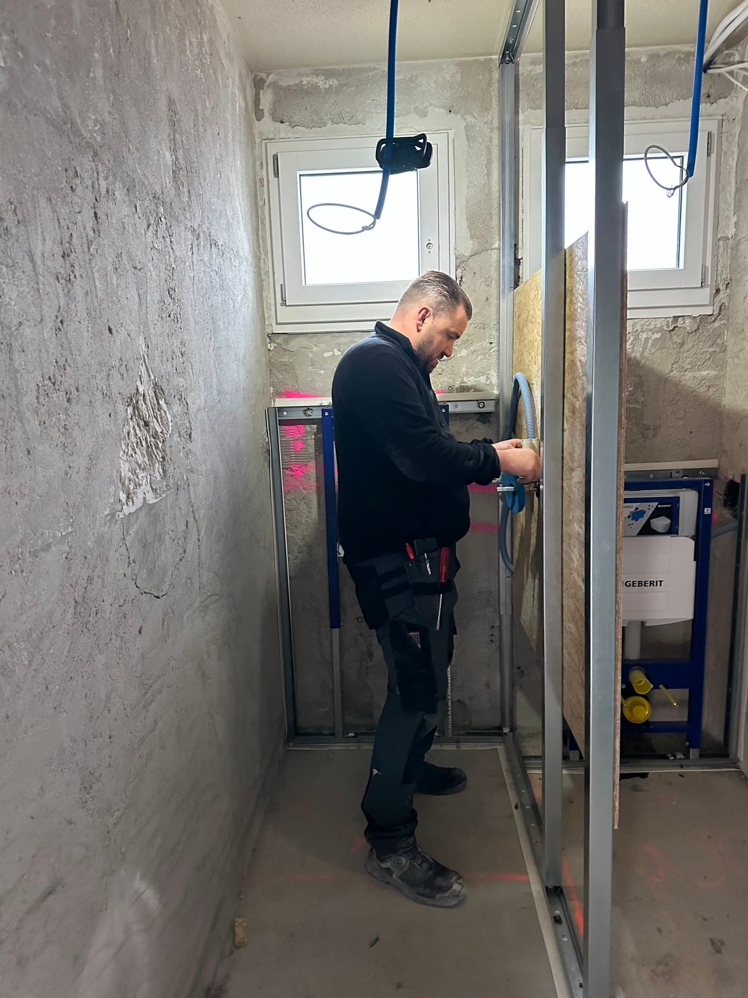 ICK-Techniker montiert die Sanitärinstallation im Rohbau des Bads, Kanton Zürich