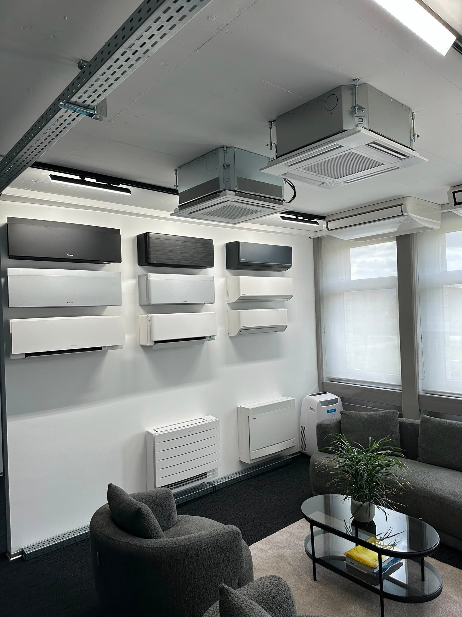 Showroom von ICK in Weiningen: Gerätewand mit Klimageräten und Sitzecke