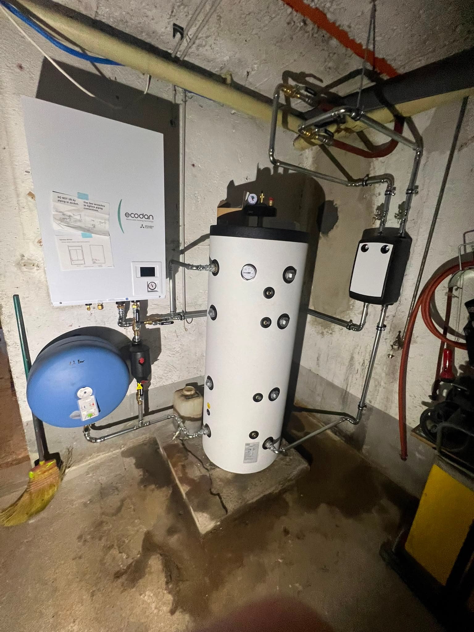 Neue Mitsubishi-Ecodan-Wärmepumpe mit Speicher im selben Heizungsraum, sauber verrohrt
