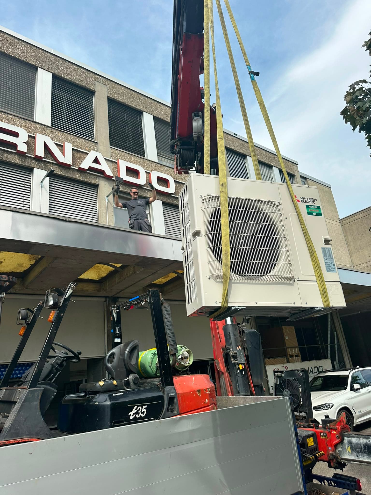 Kraneinsatz bei der Montage eines Klima-Aussengeräts an einem Gewerbegebäude, Kanton Zürich