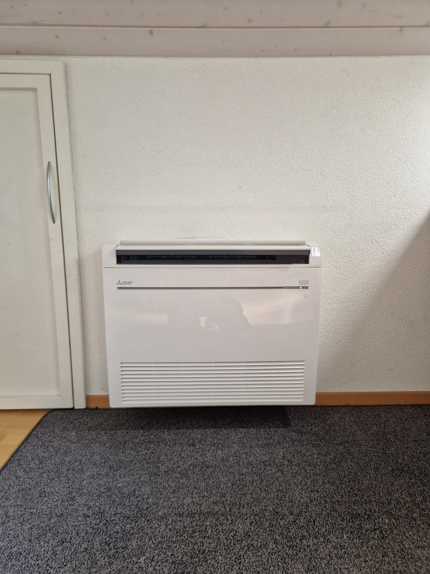 Truhengerät einer Klimaanlage bodennah an der Wand, Wohnraum im Kanton Zürich