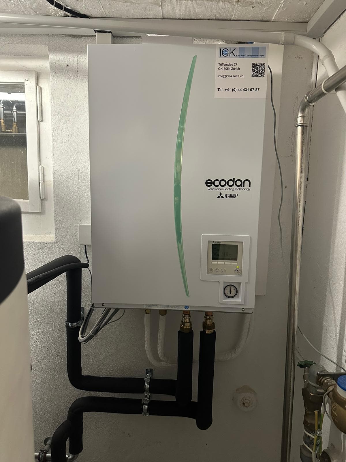 Mitsubishi-Ecodan-Hydrobox an der Wand im Technikraum, sauber verrohrt, Kanton Zürich