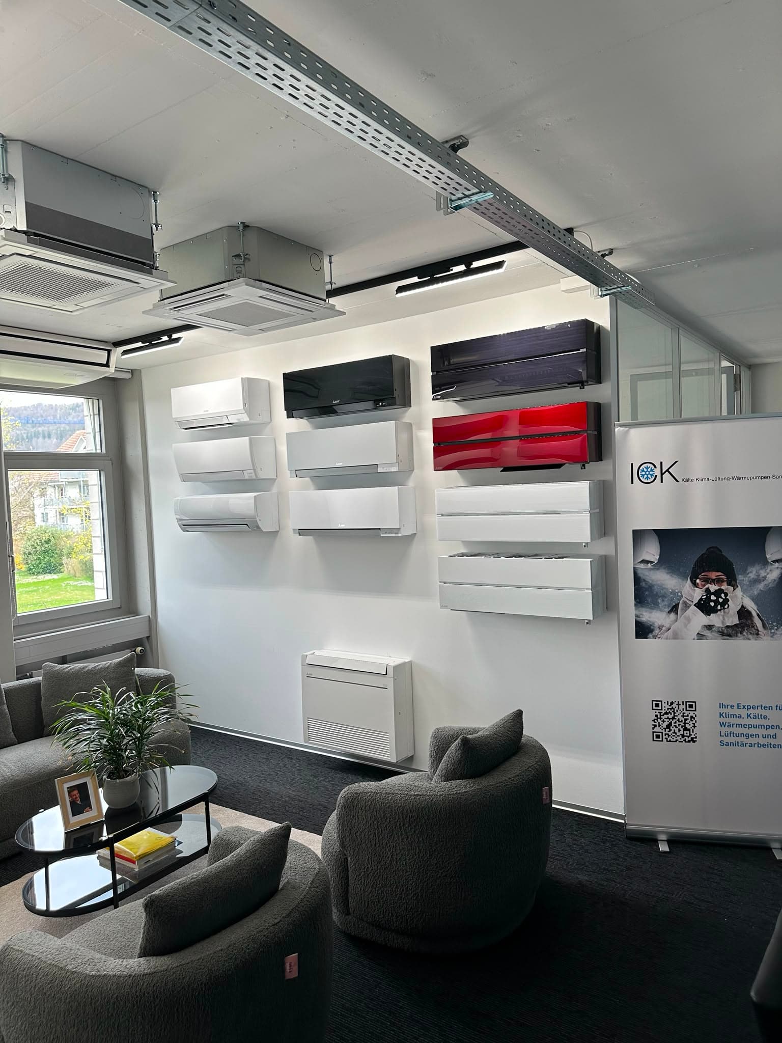 Showroom von ICK in Weiningen: Gerätewand mit verschiedenen Klimageräten und Sitzecke