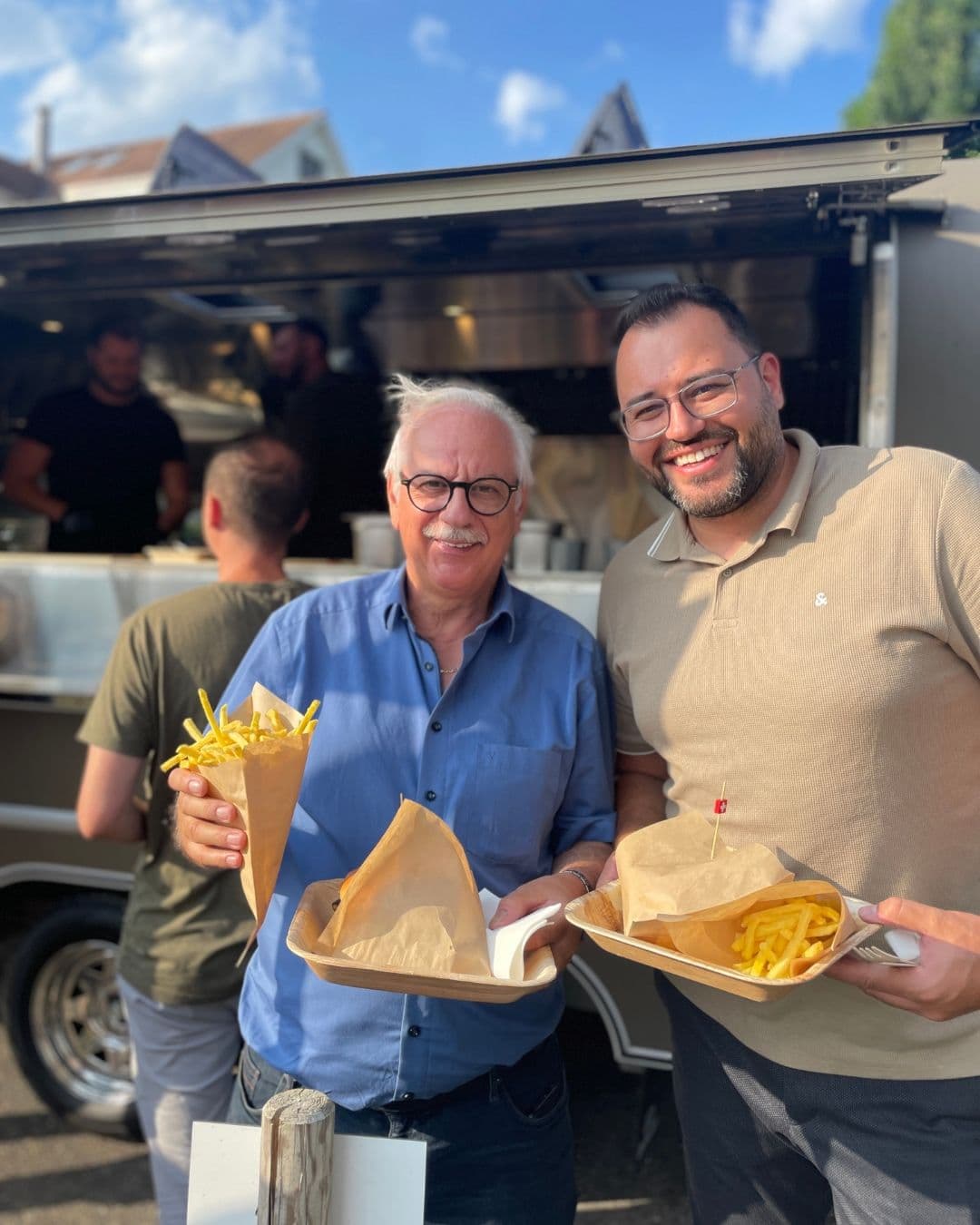 Zwei Mitarbeiter der ICK Group am Foodtruck beim Sommerfest