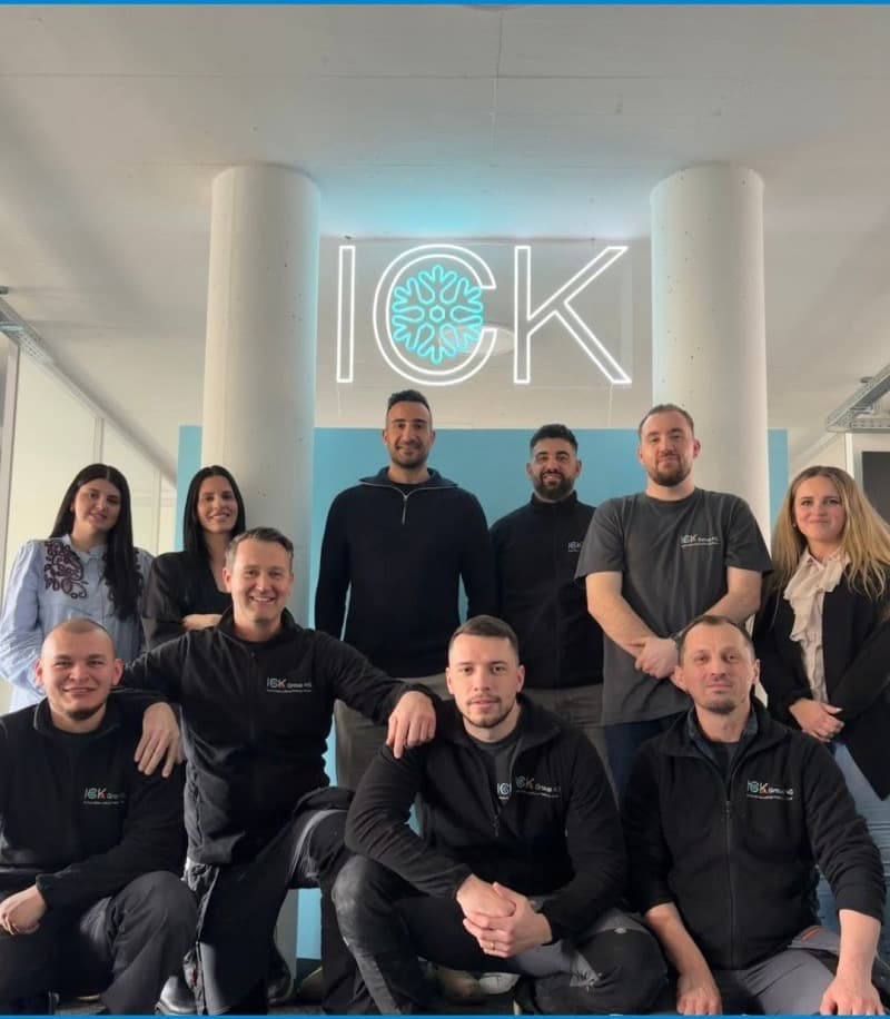 Das Team der ICK Group AG unter dem beleuchteten ICK-Logo im Büro in Weiningen